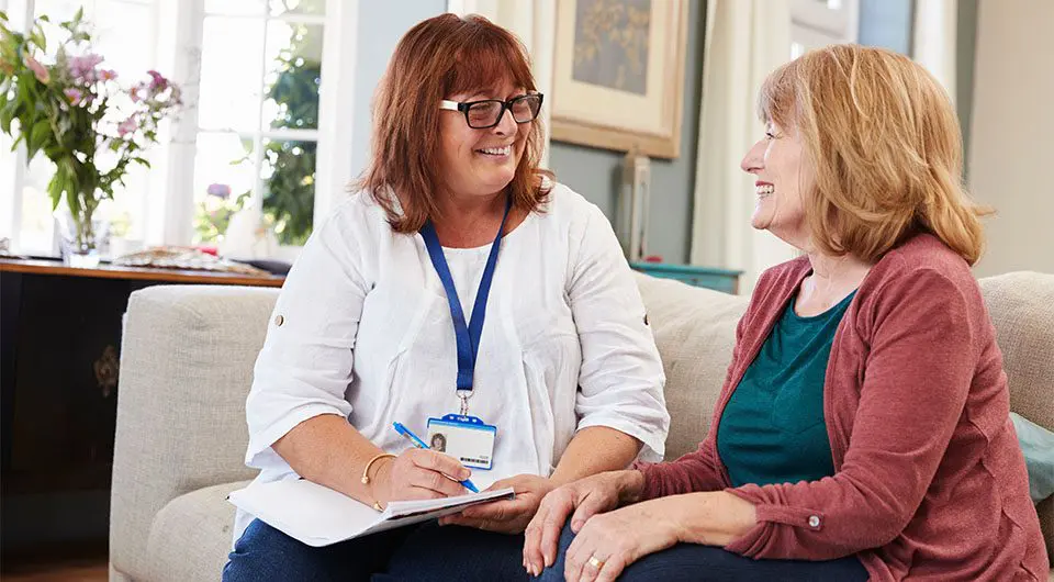 A friendly nurse talks with a patient.