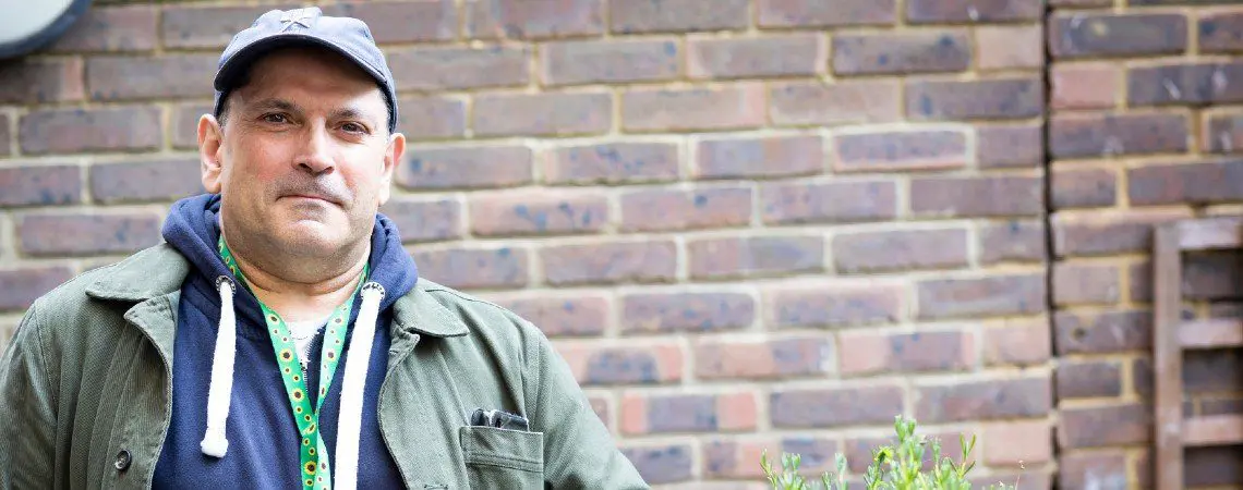 A middle aged man wearing a hoodie and cap