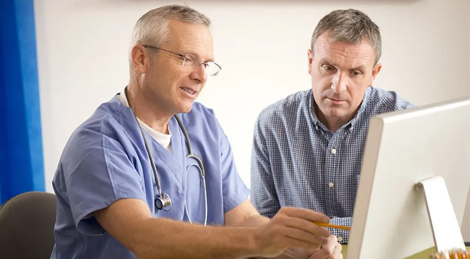 Two medical professionals study a screen together.