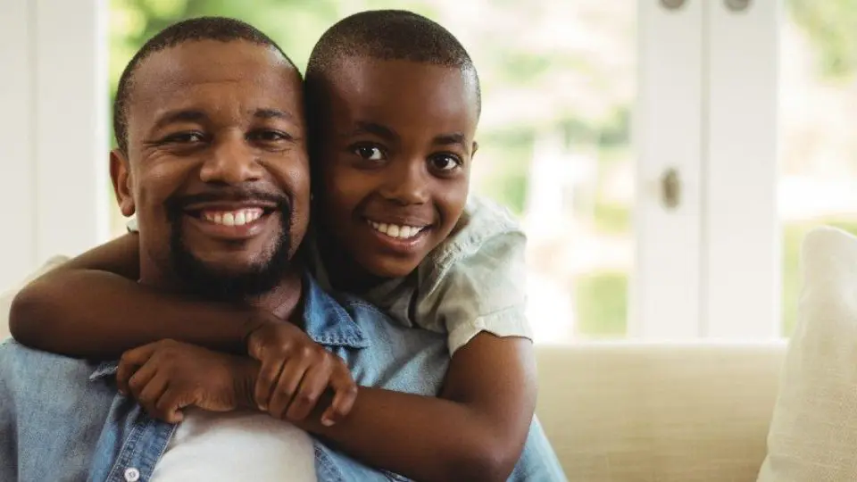 A young boy and his father pose together